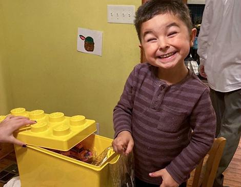 Boy smiling with new lego kit.