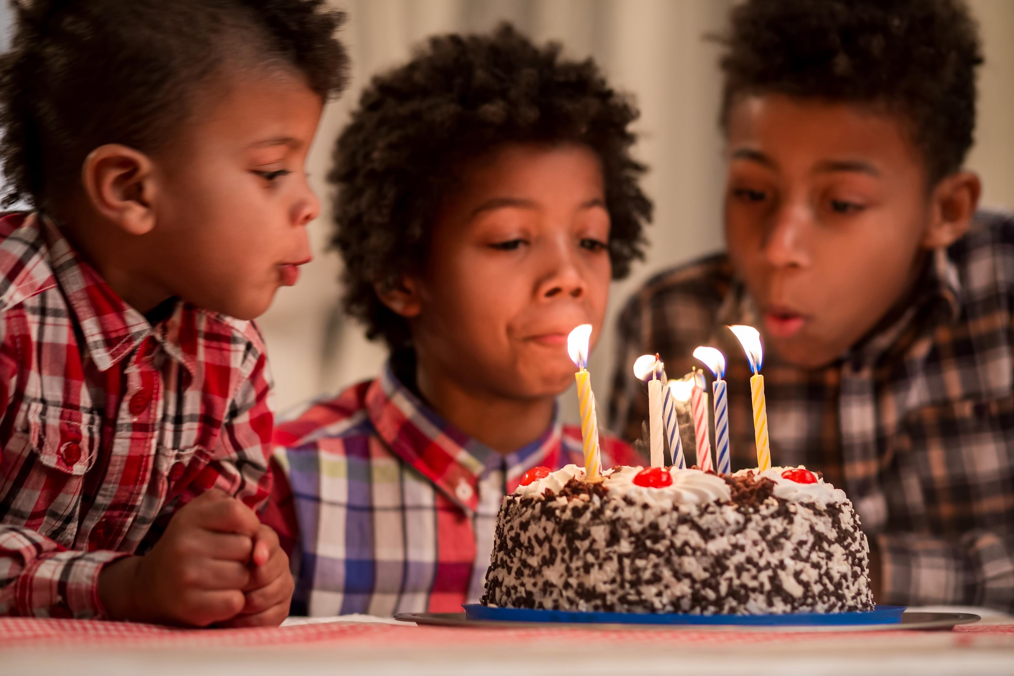 School age boys blowing out birthday candles